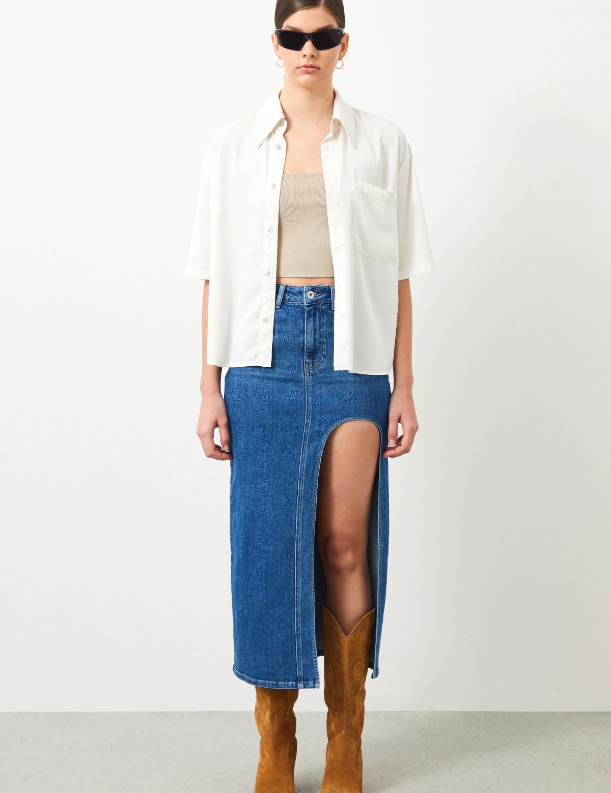 Stylish outfit combining ecru white blouse and blue denim skirt.