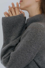 Close-up of the wide sleeve on a grey cashmere sweater by Nuage Cashmere, showcasing the soft, knitted texture of 100% Italian cashmere