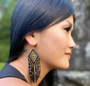 Woman wearing Beaded Tribal Diamond Fringe Earrings at Music Festival -  Profile view with gold accents.