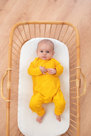 baby in Tilouco's Mustard Yellow Baby Grow
