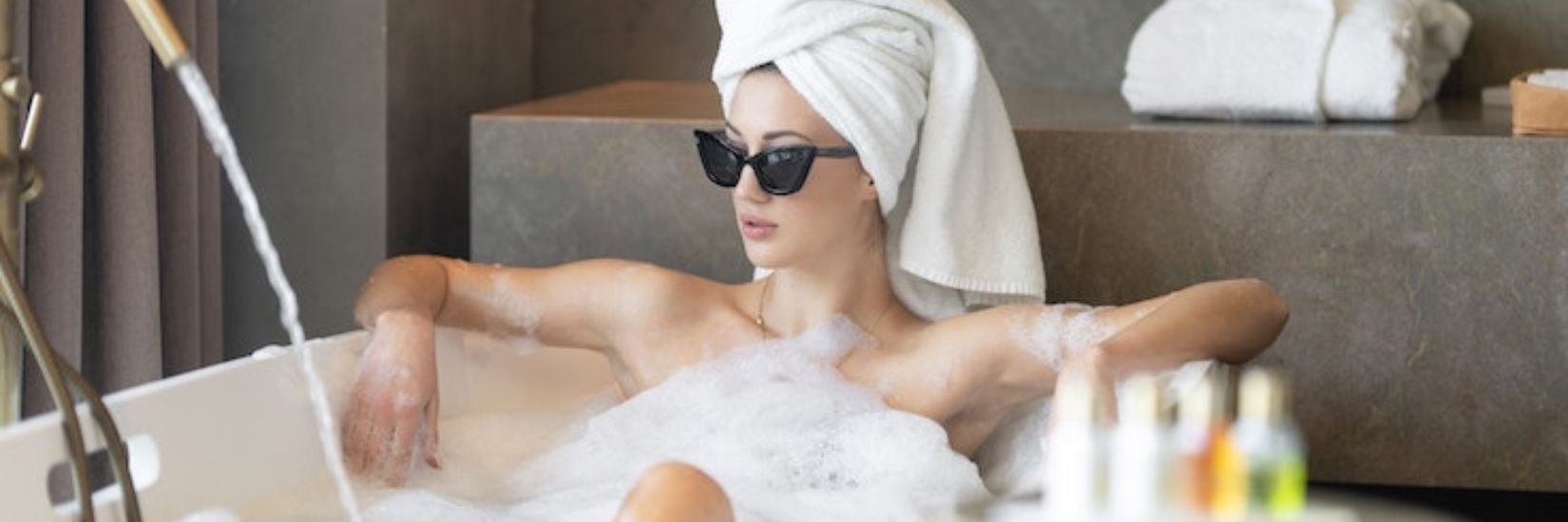 Women having a bath with her favourite natural bodycare products