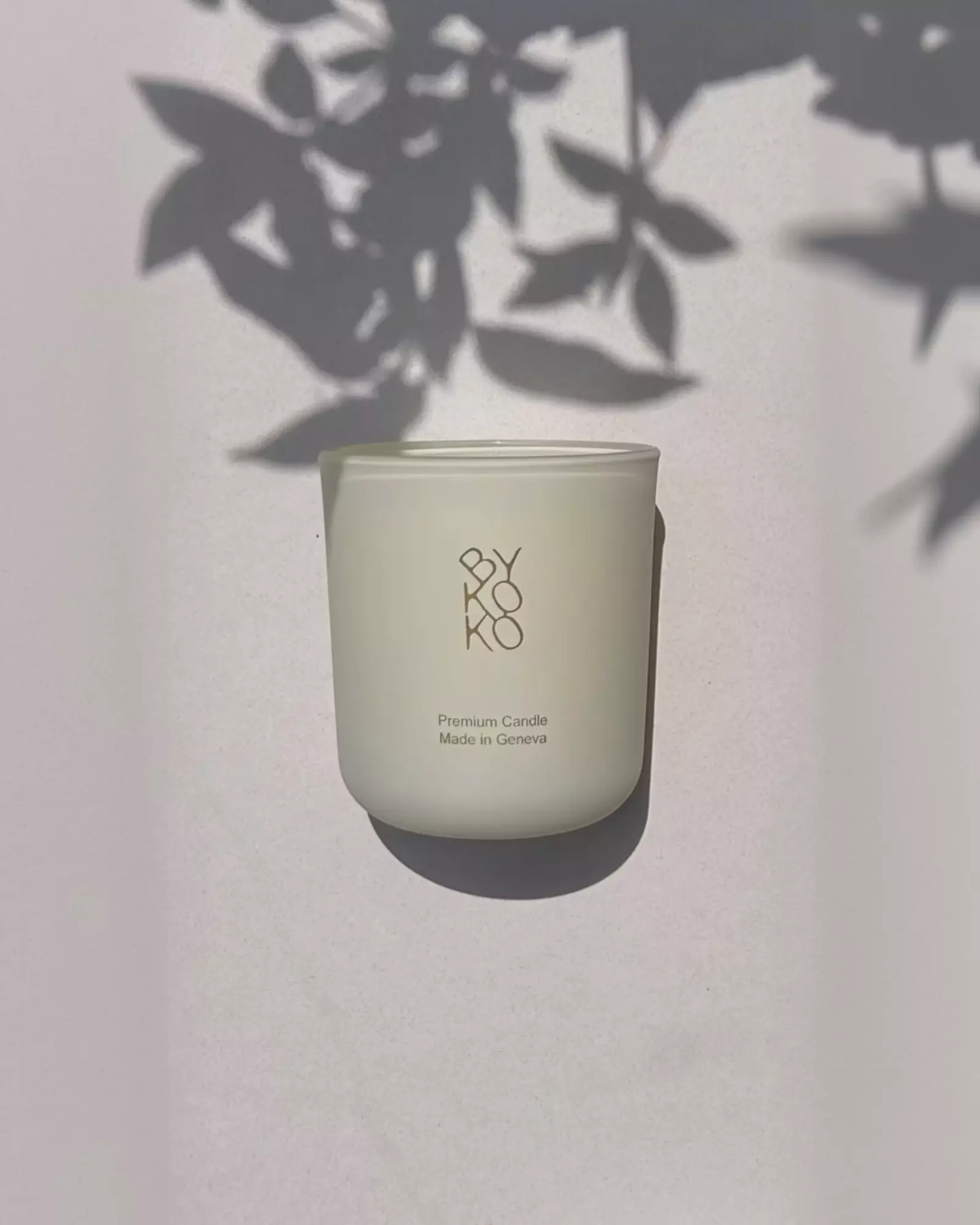 BYKOKO Cosy Cottage scented candle in frosted glass with soft leaf shadows