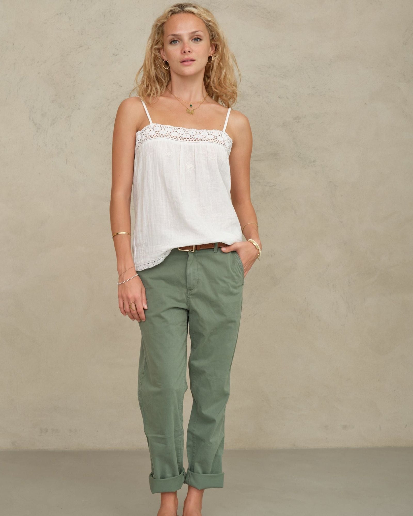 Front view of a model posing in a white bohemian-style cotton camisole from Mabe Apparel.