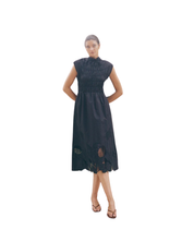 Black sleeveless MMAria Mono dress in breathable organic cotton featuring a smocked bodice and intricate floral embroidery. Ideal for sustainable summer occasion styling.