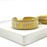 Close-up of adjustable woven friendship bracelet with silver phrase and tassels
