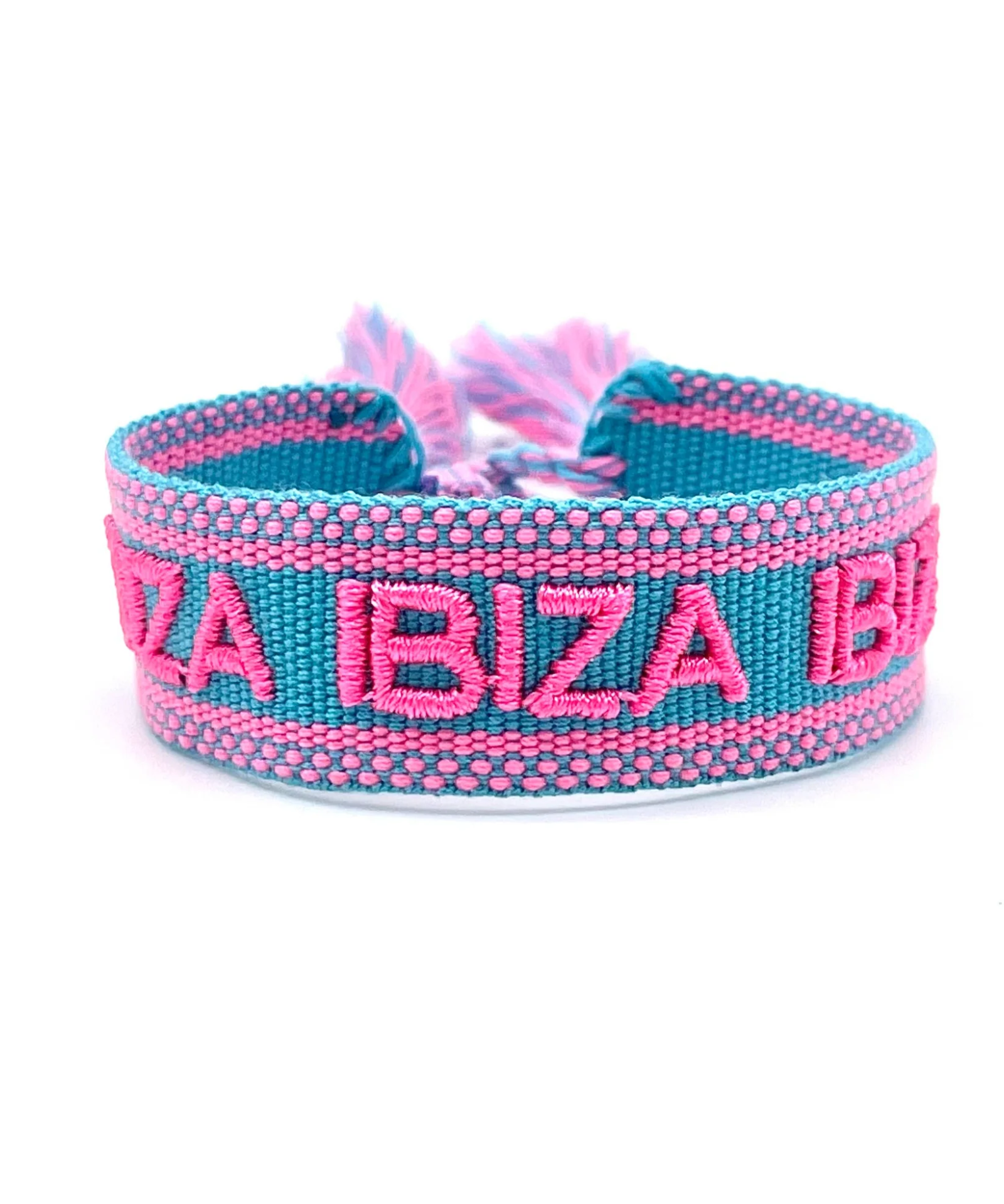 Close-up of adjustable turquoise woven friendship bracelet with pink border and embroidered "IBIZA IBIZA IBIZA" lettering with sliding knot cords.