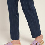 Person wearing navy pinstripe pants and purple sandals 