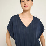 Woman wearing a navy pinstripe jumpsuit