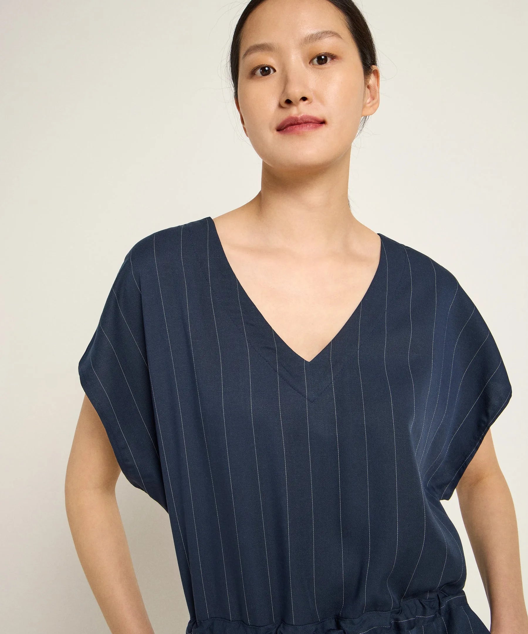 Woman wearing a navy pinstripe jumpsuit