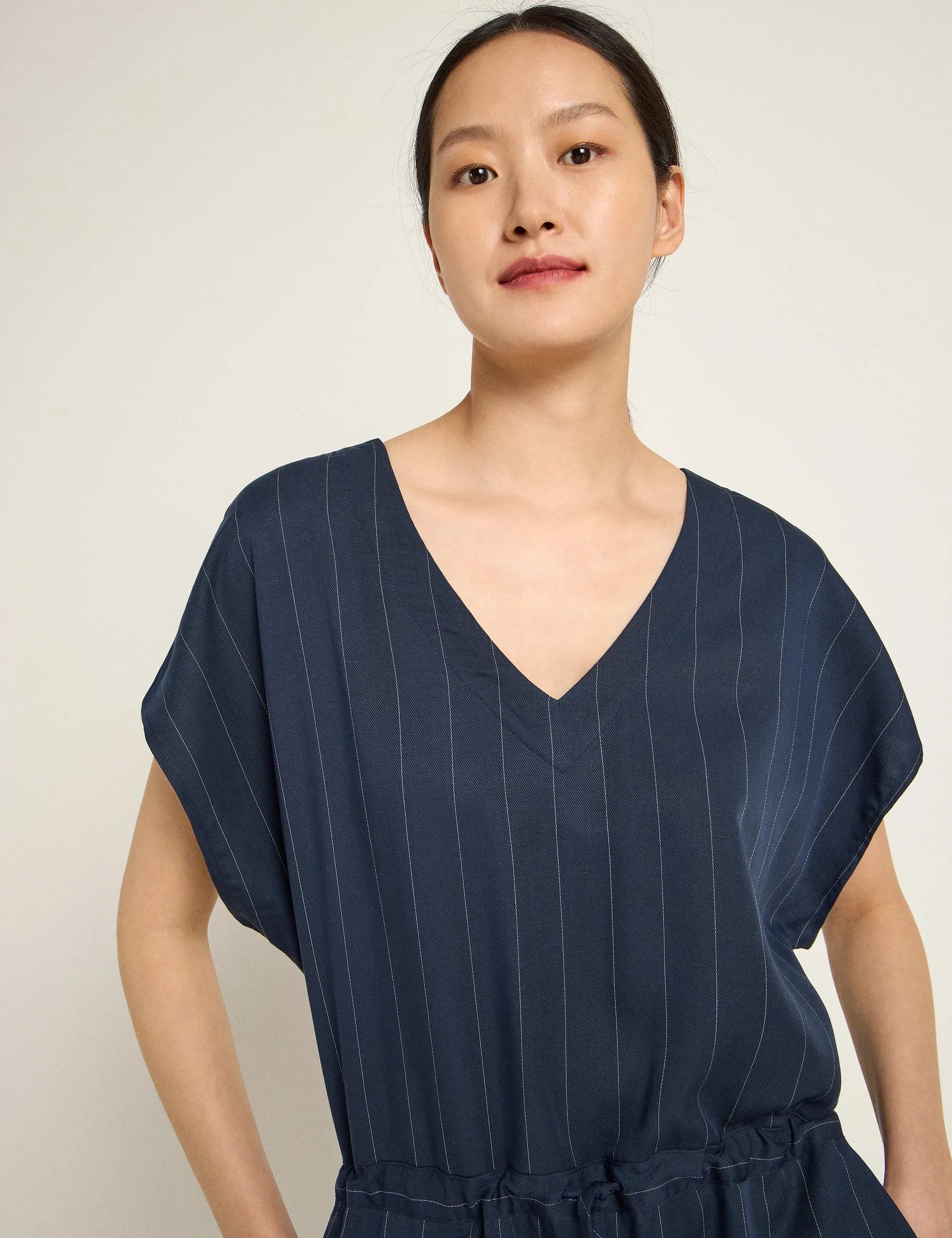 Woman wearing a navy pinstripe jumpsuit