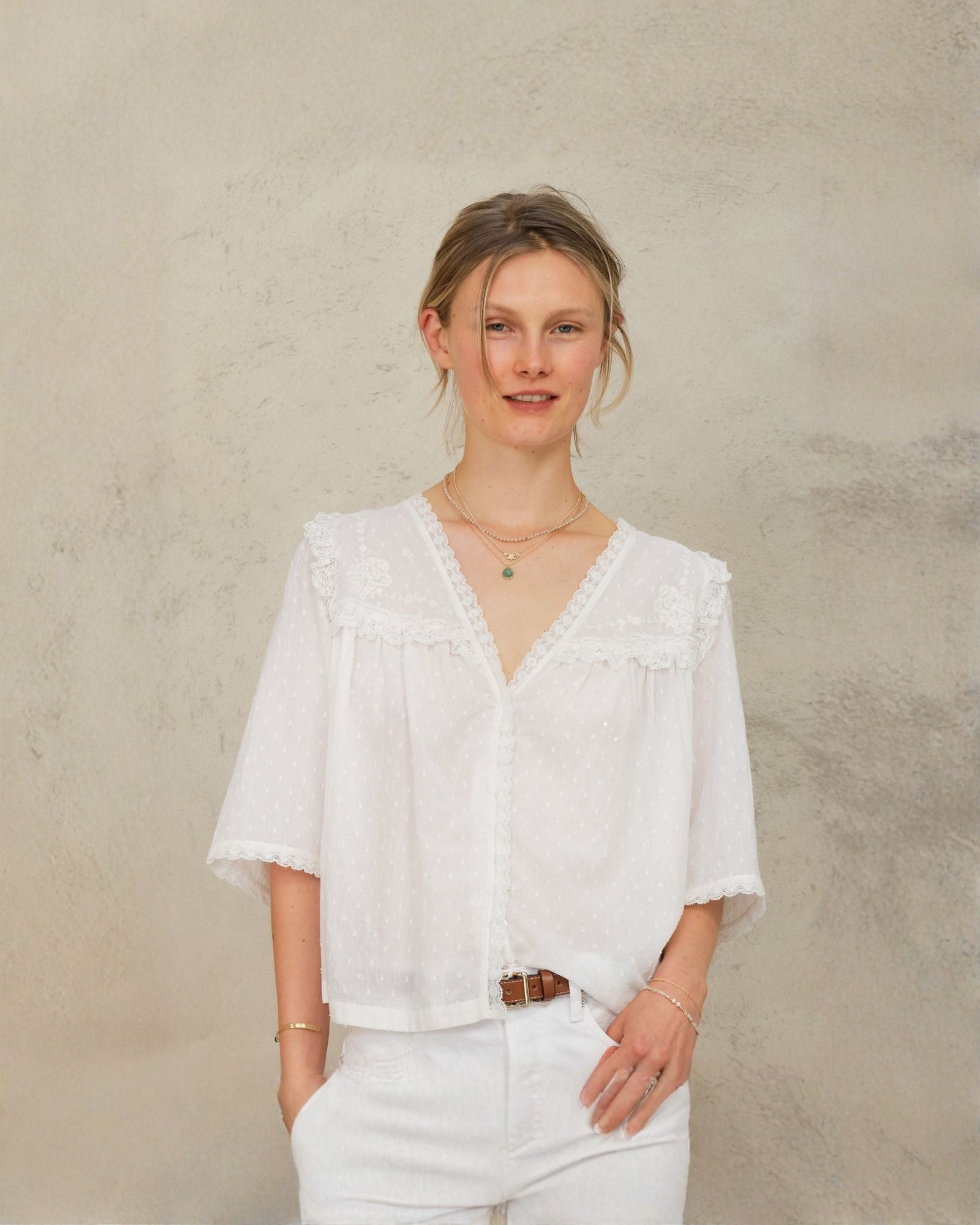 Model wearing Frill Detail Blouse in Ivory styled with white jeans.