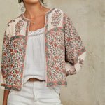Detailed view of the collarless neckline and billowy sleeves on a Mabe Apparel floral print cotton jacket.