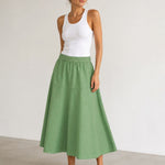 Woman wearing Mos Mosh MMEllaja sage green A-line midi skirt, styled with white tank top