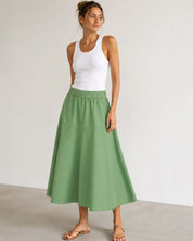 Woman wearing Mos Mosh MMEllaja sage green A-line midi skirt, styled with white tank top