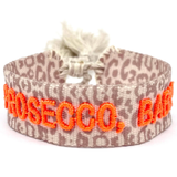 Close-up of adjustable woven friendship bracelet with Leo pattern and neon orange embroidered "PROSECCO, BABY!" lettering with sliding knot cords.