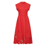 Model sitting wearing MMAria Mono Dress in Soft Coral, embroidered detail visible