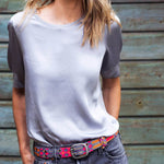 Woman wearing the Adriana Peppy Handwoven Belt by Smitten in grey and pink, styled with a casual dress for a chic, colorful look