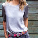Woman wearing the Adriana Peppy Handwoven Belt by Smitten in grey and pink, styled with a casual dress for a chic, colorful look