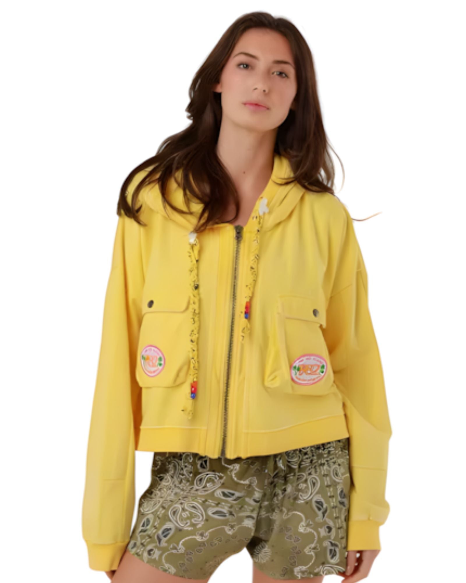 A woman wearing the vibrant yellow Amy cotton zip-up hooded jacket with cargo chest pockets and colorful beaded drawstring details.