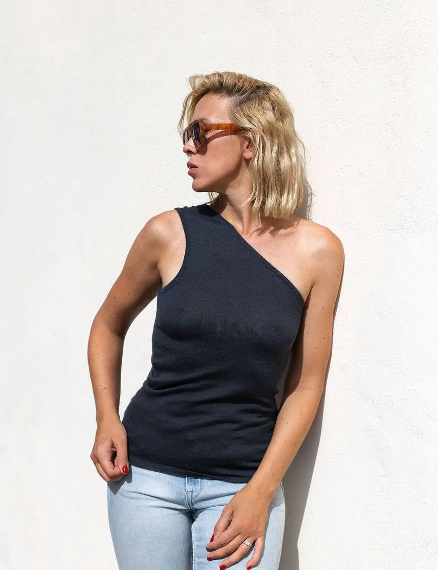 Model wearing the sleeveless anthracite one-shoulder top with light blue jeans, styled for a summer afternoon