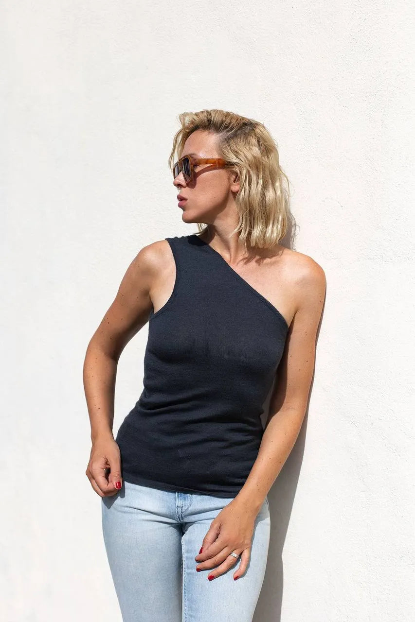 Model wearing the sleeveless anthracite one-shoulder top with light blue jeans, styled for a summer afternoon