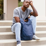 Model wearing the ARSAYO Mela backpack in storm blue AppleSkin