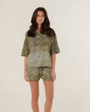 Full-length front view of a model wearing the relaxed fit green bandana print cotton shorts with a matching oversized patterned shirt.