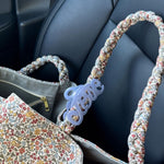 Bon Dep Love Hair Claw 8cm lavender clipped onto a floral-patterned handbag strap.