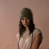 COLORUSH Byron beanie in Kiwi, model seated with burgundy gloves