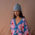 COLORUSH Byron cashmere beanie in Stonewash, worn from the front with a pink and blue cardigan