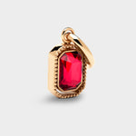 Coluri Talisman charm with a scarlet stone in a gold setting