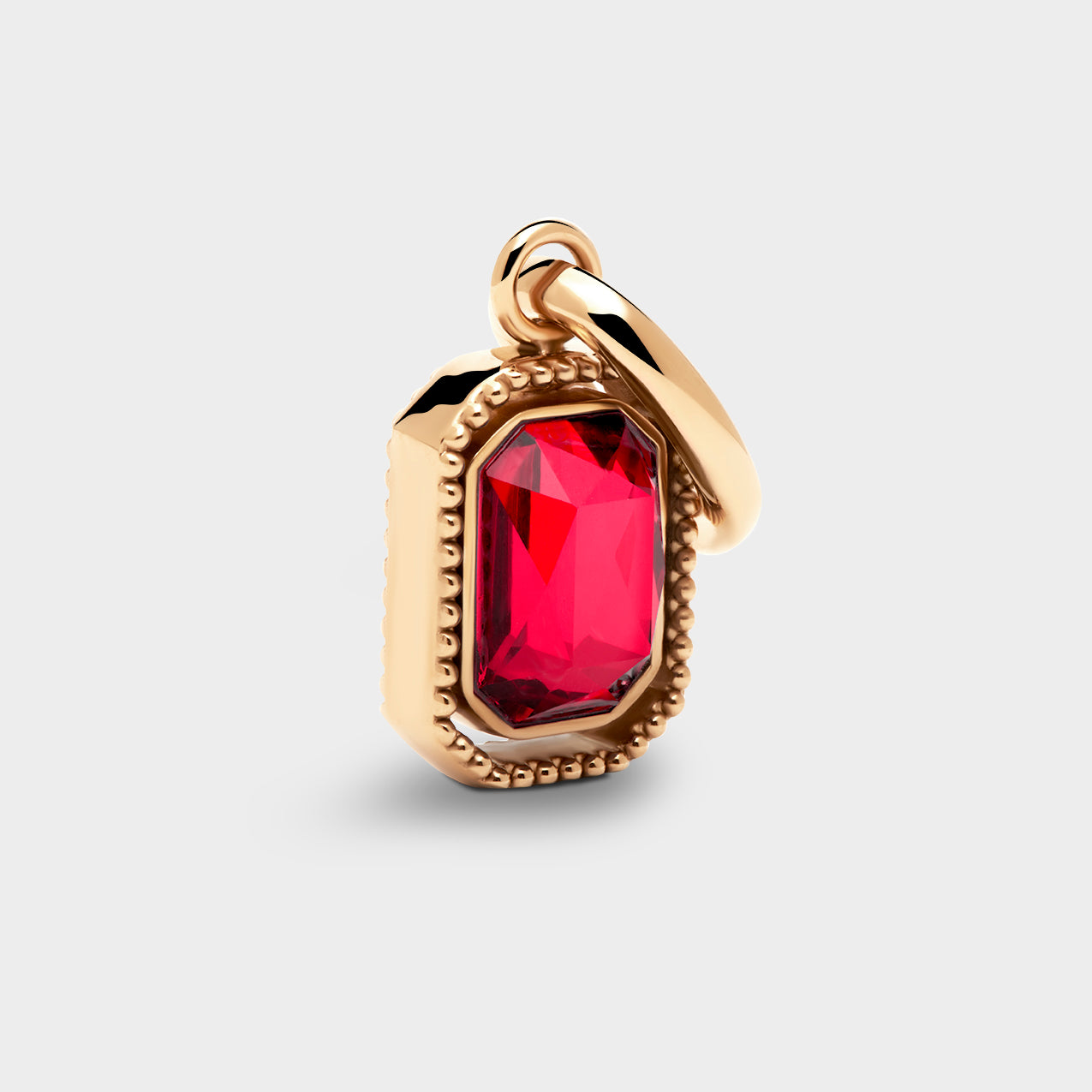 Coluri Talisman charm with a scarlet stone in a gold setting