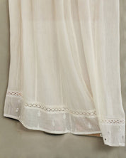 Detailed close-up of the openwork crochet lace and delicate embroidery on a cream Mabe Apparel skirt.