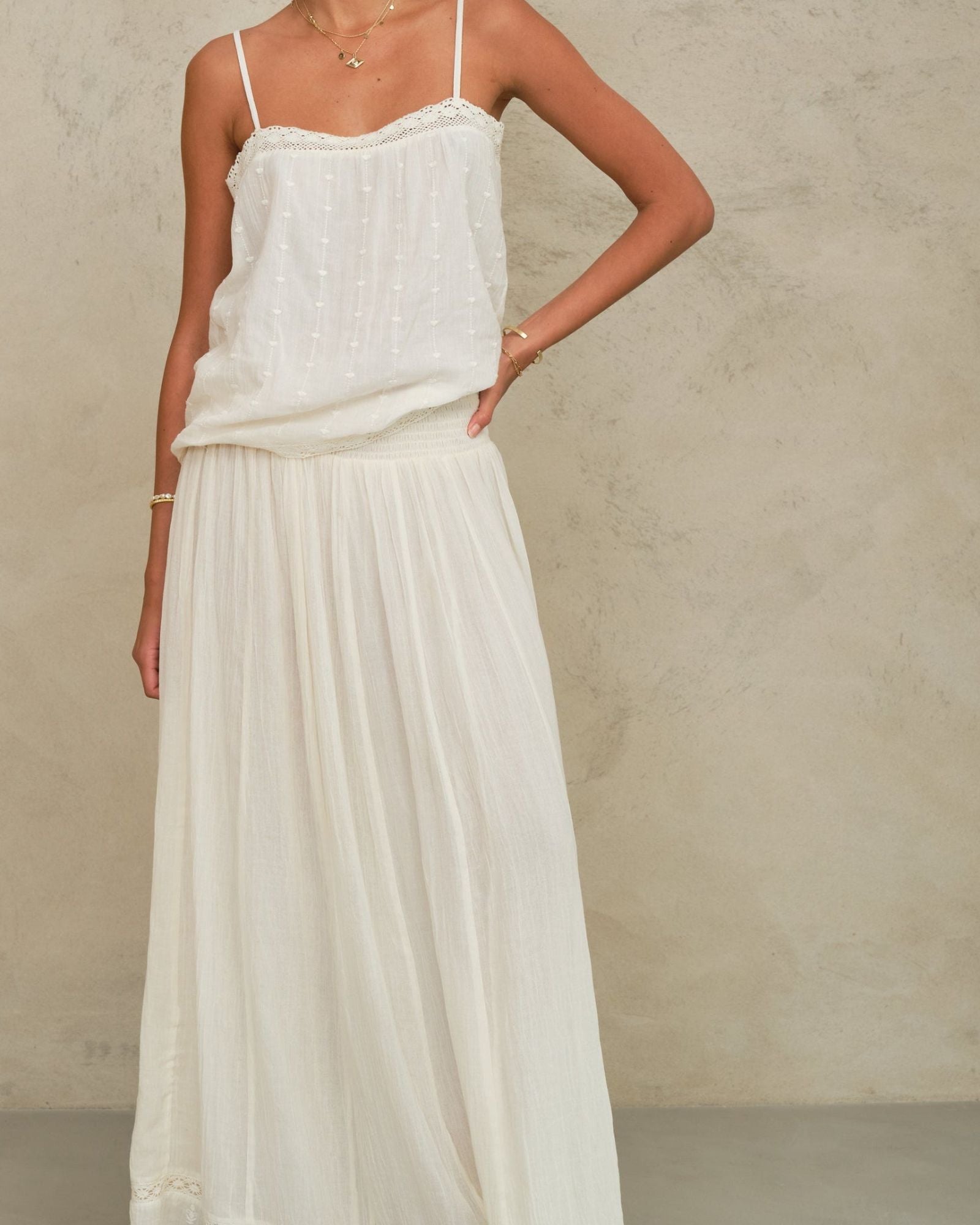 Model wearing the Mabe Apparel cream tiered maxi skirt paired with a white strappy cotton top.