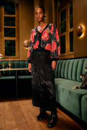 Woman wearing the Farm Rio black leopard jacquard maxi skirt in a stylish evening setting
