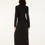 Full-length back studio view of a model wearing the Farm Rio black maxi skirt, displaying the clean floor-skimming silhouette.
