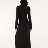 Full-length back studio view of a model wearing the Farm Rio black maxi skirt, displaying the clean floor-skimming silhouette.