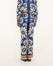 Back view of a model showcasing the fit and continuous blue botanical pattern of the Farm Rio wide-leg pajama pants.