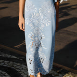 Close-up view of the intricate Richelieu embroidery and scalloped wavy hem on the FARM Rio denim midi skirt.