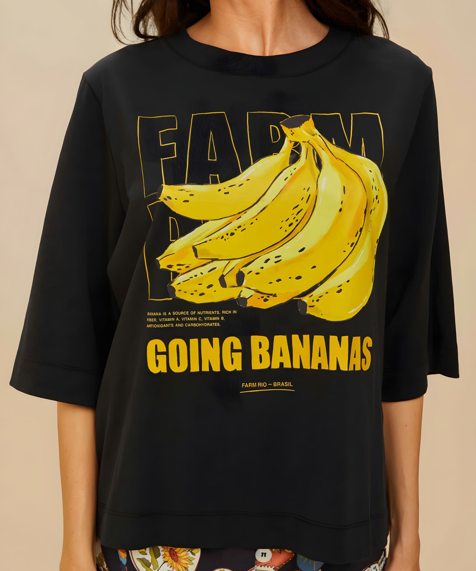 Detailed view of the yellow Going Bananas graphic print on the front of the black FARM Rio t-shirt