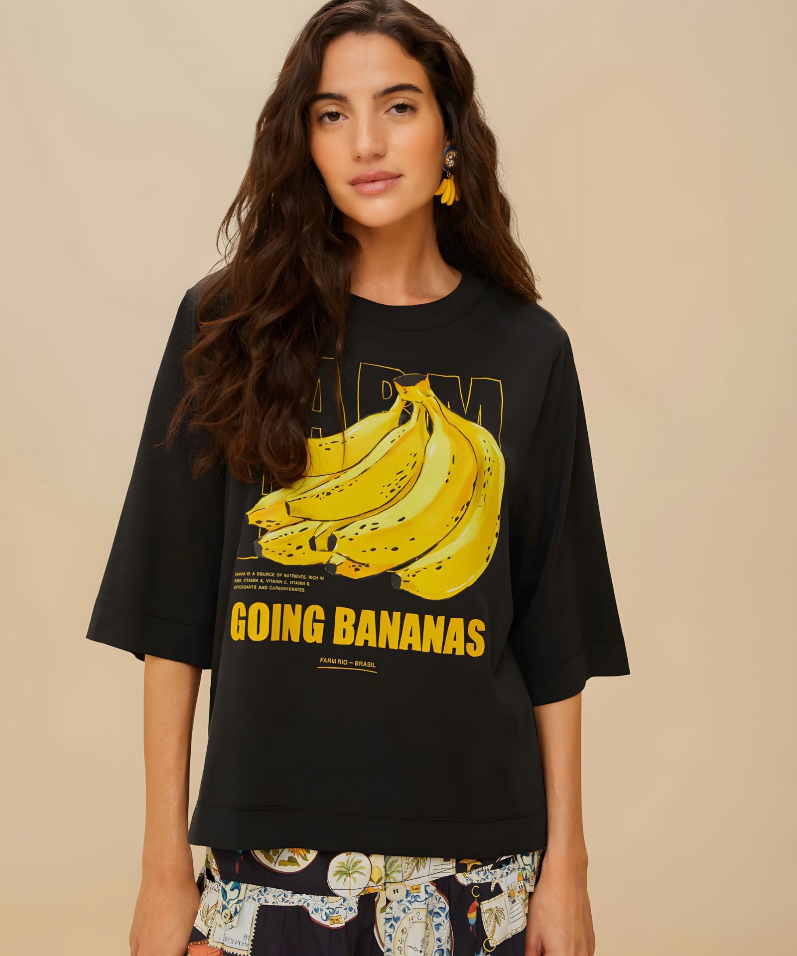 Model wearing FARM Rio black organic cotton t-shirt with Going Bananas graphic print, close-up front view