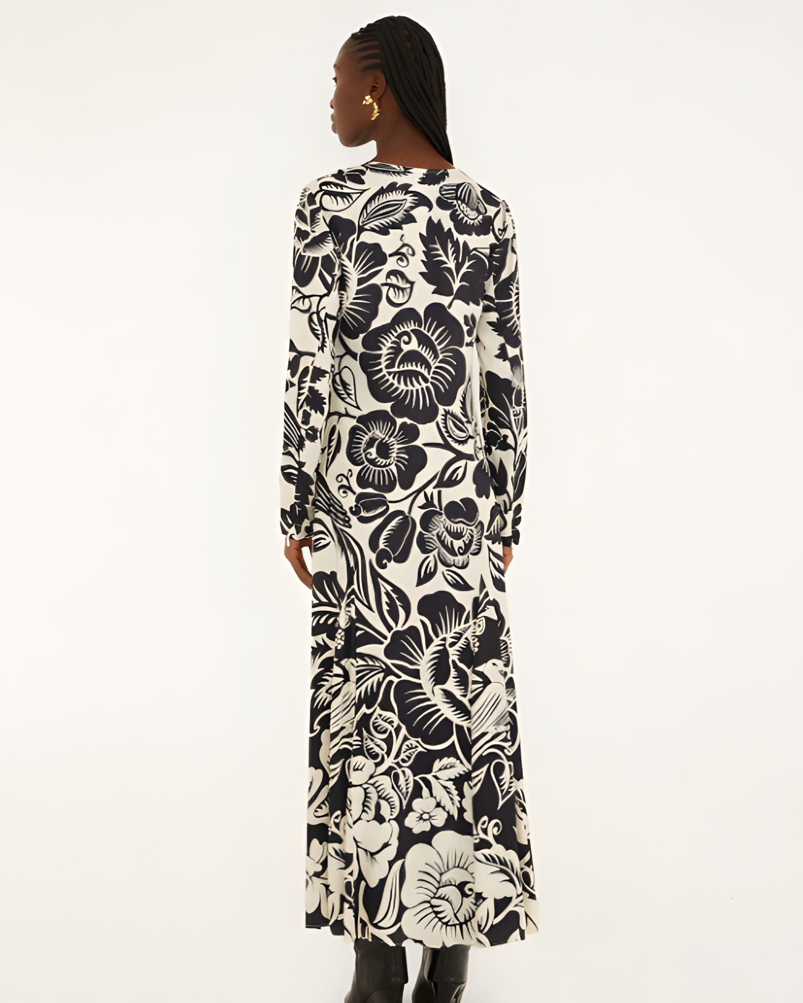 Back view of a model showcasing the continuous black and off-white botanical pattern across the Farm Rio long-sleeve maxi dress.