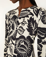 Close-up view of the Farm Rio Off-White Cashews and Birds maxi dress, highlighting the detailed slit V-neckline and artistic contrast print.