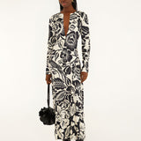 Full-length front view of a model in a studio wearing the Farm Rio Off-White Cashews and Birds viscose maxi dress with long sleeves and a bold graphic print.