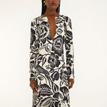 Front view of a model highlighting the sleek column silhouette and sophisticated deep V-neckline slit of the Farm Rio printed maxi dress.