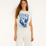 Full-length studio front view of a model styling the Farm Rio padded shoulder t-shirt with matching off-white pants.