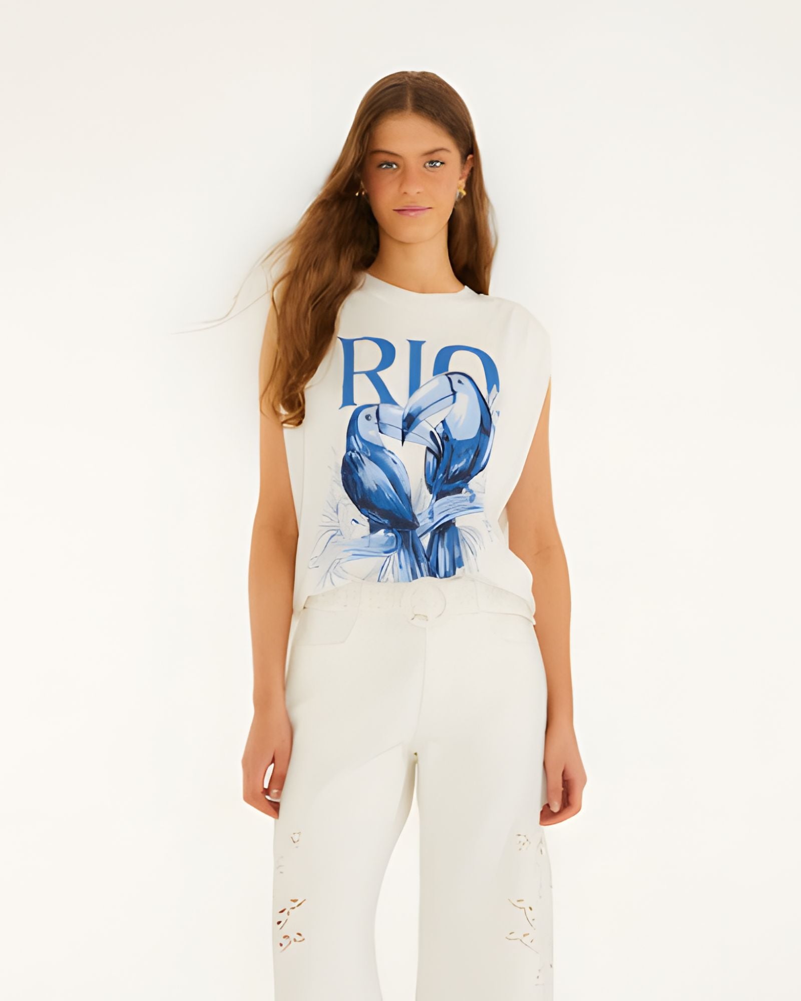 Full-length studio front view of a model styling the Farm Rio padded shoulder t-shirt with matching off-white pants.