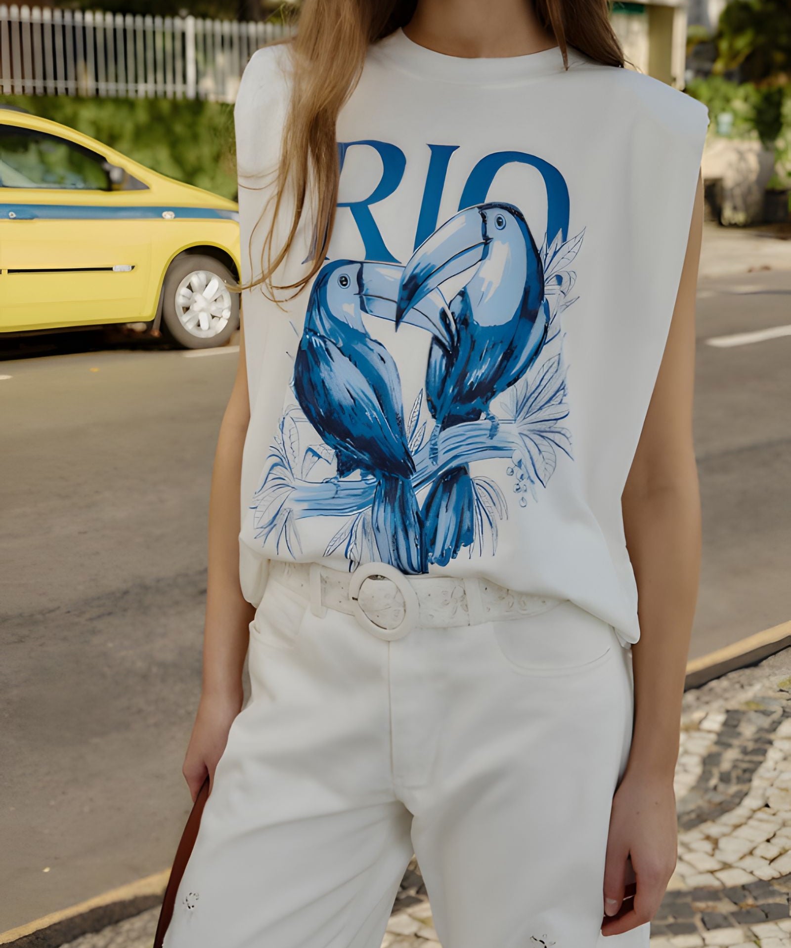 Close-up view of the Farm Rio sleeveless t-shirt, highlighting the bold blue Toucan Rio graphic print and structured shoulder padding.