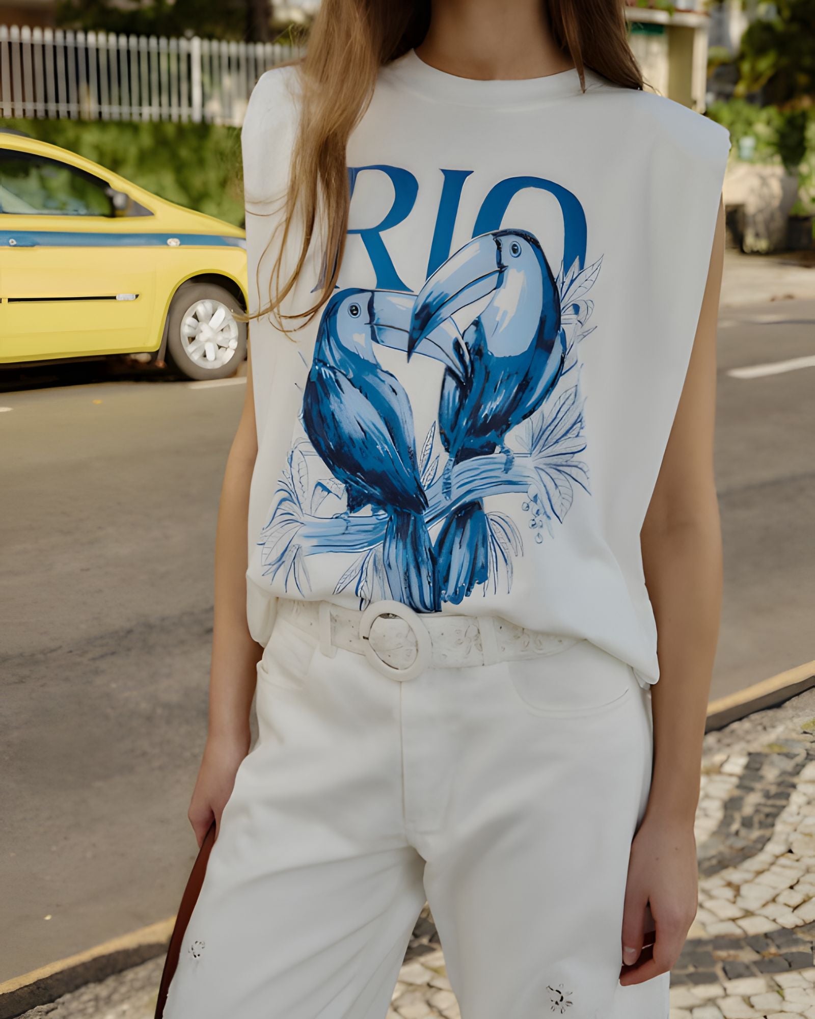 Close-up view of the Farm Rio sleeveless t-shirt, highlighting the bold blue Toucan Rio graphic print and structured shoulder padding.