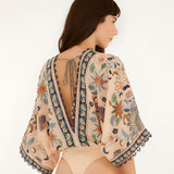 Back view of the model wearing the Farm Rio floral tapestry bodysuit with a deep V-cut back.